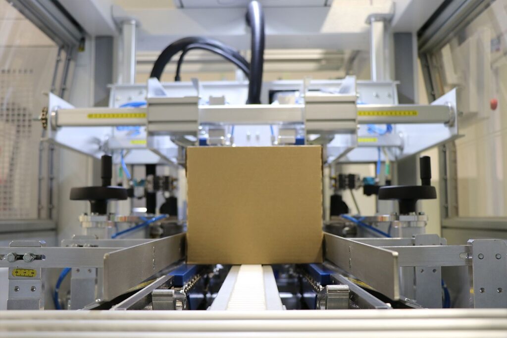Máquinas Encartonadoras donde se puede apreciar una caja de cartón que está a punto de ser embalada